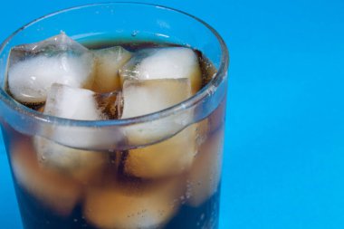 Kola ve buz bir bardakta. Karbonatlı içecek. Beyaza izole edilmiş buzlu tatlı karbonatlı içecekler. Kırpma yolu ile. Buzlu ve köpüklü kolanın arka planı.