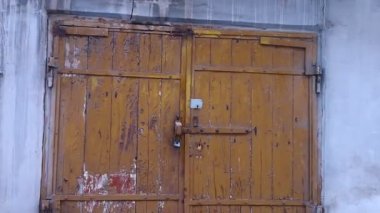 Eski kapı. Garaj kapıları. Eski evin kapıları. Eski kaleler. Eski bir köy ahır kapısı, ev, garaj. Tahtadan yapılmış, asma kilit kapıda asılı. Fotoğraf koyu renklerde.