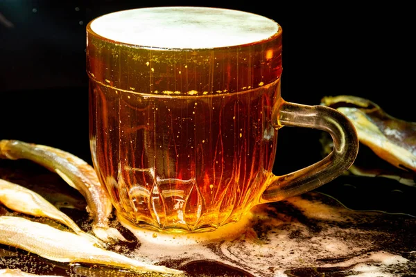 暗い背景にビールのマグカップ ビールグラス ビールと魚 ガラスの泡だ ガス泡だ 軽ビールのグラス 暗いテーブルの上にビールグラス ストックフォト 冷たい泡立ちビールのマグカップのクローズアップ — ストック写真