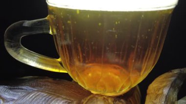 Siyah arka planda bir kupa bira. Bira bardağı. Bira ve balık. Bardakta köpük. Gaz baloncukları. Bir bardak light bira. Koyu bir masada bira bardakları. Soğuk köpüklü biranın foto fincanı..