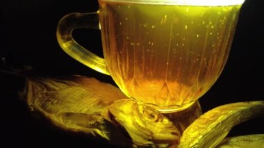 Siyah arka planda bir kupa bira. Bira bardağı. Bira ve balık. Bardakta köpük. Gaz baloncukları. Bir bardak light bira. Koyu bir masada bira bardakları. Soğuk köpüklü biranın foto fincanı..