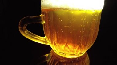 Siyah arka planda bir kupa bira. Bira bardağı. Bira ve balık. Bardakta köpük. Gaz baloncukları. Bir bardak light bira. Koyu bir masada bira bardakları. Soğuk köpüklü biranın foto fincanı..