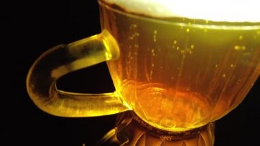 Siyah arka planda bir kupa bira. Bira bardağı. Bira ve balık. Bardakta köpük. Gaz baloncukları. Bir bardak light bira. Koyu bir masada bira bardakları. Soğuk köpüklü biranın foto fincanı..