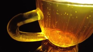 Siyah arka planda bir kupa bira. Bira bardağı. Bira ve balık. Bardakta köpük. Gaz baloncukları. Bir bardak light bira. Koyu bir masada bira bardakları. Soğuk köpüklü biranın foto fincanı..