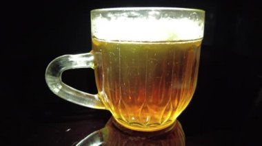 Siyah arka planda bir kupa bira. Bira bardağı. Bira ve balık. Bardakta köpük. Gaz baloncukları. Bir bardak light bira. Koyu bir masada bira bardakları. Soğuk köpüklü biranın foto fincanı..