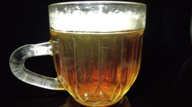 Siyah arka planda bir kupa bira. Bira bardağı. Bira ve balık. Bardakta köpük. Gaz baloncukları. Bir bardak light bira. Koyu bir masada bira bardakları. Soğuk köpüklü biranın foto fincanı..