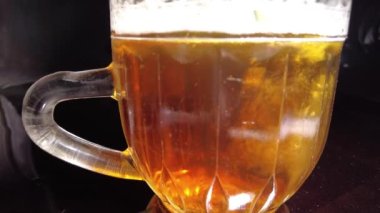 Siyah arka planda bir kupa bira. Bira bardağı. Bira ve balık. Bardakta köpük. Gaz baloncukları. Bir bardak light bira. Koyu bir masada bira bardakları. Soğuk köpüklü biranın foto fincanı..