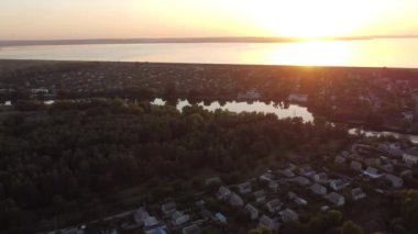 Hava aracı videosundan şafak söküyor. İnsansız hava aracı nefes kesici kırsal alan ve tarım arazisi üzerinde uçuyor. Sinematik hava çekimi. Gün batımında kuşbakışı akan kıvrımlı nehir.