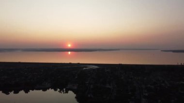 Hava aracı videosundan şafak söküyor. İnsansız hava aracı nefes kesici kırsal alan ve tarım arazisi üzerinde uçuyor. Sinematik hava çekimi. Gün batımında kuşbakışı akan kıvrımlı nehir.