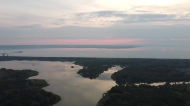 Hava aracı videosundan şafak söküyor. İnsansız hava aracı nefes kesici kırsal alan ve tarım arazisi üzerinde uçuyor. Sinematik hava çekimi. Gün batımında kuşbakışı akan kıvrımlı nehir.
