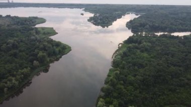 Hava aracı videosundan şafak söküyor. İnsansız hava aracı nefes kesici kırsal alan ve tarım arazisi üzerinde uçuyor. Sinematik hava çekimi. Gün batımında kuşbakışı akan kıvrımlı nehir.