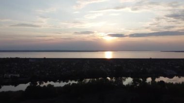 Hava aracı videosundan şafak söküyor. İnsansız hava aracı nefes kesici kırsal alan ve tarım arazisi üzerinde uçuyor. Sinematik hava çekimi. Gün batımında kuşbakışı akan kıvrımlı nehir.