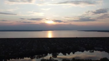 Hava aracı videosundan şafak söküyor. İnsansız hava aracı nefes kesici kırsal alan ve tarım arazisi üzerinde uçuyor. Sinematik hava çekimi. Gün batımında kuşbakışı akan kıvrımlı nehir.