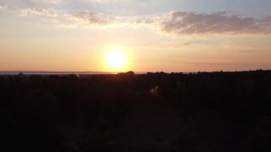 Hava aracı videosundan şafak söküyor. İnsansız hava aracı nefes kesici kırsal alan ve tarım arazisi üzerinde uçuyor. Sinematik hava çekimi. Gün batımında kuşbakışı akan kıvrımlı nehir.