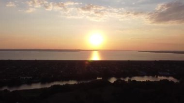 Hava aracı videosundan şafak söküyor. İnsansız hava aracı nefes kesici kırsal alan ve tarım arazisi üzerinde uçuyor. Sinematik hava çekimi. Gün batımında kuşbakışı akan kıvrımlı nehir.