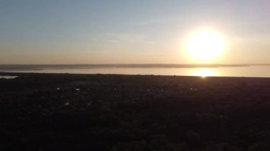 Hava aracı videosundan şafak söküyor. İnsansız hava aracı nefes kesici kırsal alan ve tarım arazisi üzerinde uçuyor. Sinematik hava çekimi. Gün batımında kuşbakışı akan kıvrımlı nehir.