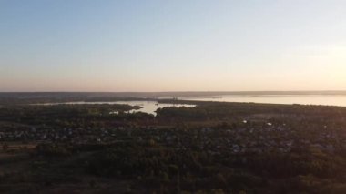 Hava aracı videosundan şafak söküyor. İnsansız hava aracı nefes kesici kırsal alan ve tarım arazisi üzerinde uçuyor. Sinematik hava çekimi. Gün batımında kuşbakışı akan kıvrımlı nehir.