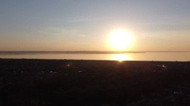 Hava aracı videosundan şafak söküyor. İnsansız hava aracı nefes kesici kırsal alan ve tarım arazisi üzerinde uçuyor. Sinematik hava çekimi. Gün batımında kuşbakışı akan kıvrımlı nehir.