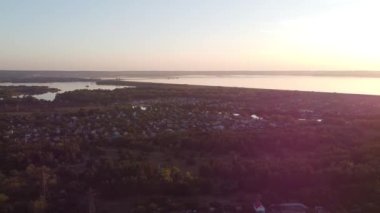 Hava aracı videosundan şafak söküyor. İnsansız hava aracı nefes kesici kırsal alan ve tarım arazisi üzerinde uçuyor. Sinematik hava çekimi. Gün batımında kuşbakışı akan kıvrımlı nehir.