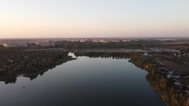 Hava aracı videosundan şafak söküyor. İnsansız hava aracı nefes kesici kırsal alan ve tarım arazisi üzerinde uçuyor. Sinematik hava çekimi. Gün batımında kuşbakışı akan kıvrımlı nehir.