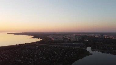 Hava aracı videosundan şafak söküyor. İnsansız hava aracı nefes kesici kırsal alan ve tarım arazisi üzerinde uçuyor. Sinematik hava çekimi. Gün batımında kuşbakışı akan kıvrımlı nehir.