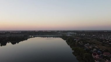 Hava aracı videosundan şafak söküyor. İnsansız hava aracı nefes kesici kırsal alan ve tarım arazisi üzerinde uçuyor. Sinematik hava çekimi. Gün batımında kuşbakışı akan kıvrımlı nehir.