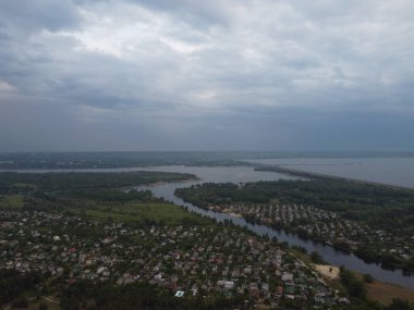 Yukarıdan suyla kaplı bir manzara. Kumlu sahil ve dalgalı okyanus manzarası. Fotoğraf yukarıdan bir dron tarafından çekildi. Doğa manzarası. Yeşil çimenli bir ormanın havadan görünüşü.
