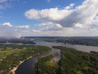 Yukarıdan suyla kaplı bir manzara. Kumlu sahil ve dalgalı okyanus manzarası. Fotoğraf yukarıdan bir dron tarafından çekildi. Doğa manzarası. Yeşil çimenli bir ormanın havadan görünüşü.