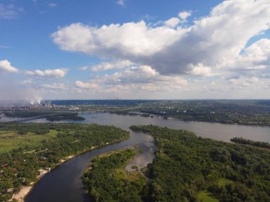 Yukarıdan suyla kaplı bir manzara. Kumlu sahil ve dalgalı okyanus manzarası. Fotoğraf yukarıdan bir dron tarafından çekildi. Doğa manzarası. Yeşil çimenli bir ormanın havadan görünüşü.