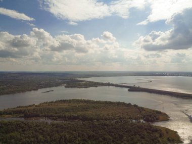 Yukarıdan suyla kaplı bir manzara. Kumlu sahil ve dalgalı okyanus manzarası. Fotoğraf yukarıdan bir dron tarafından çekildi. Doğa manzarası. Yeşil çimenli bir ormanın havadan görünüşü.