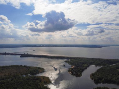 Yukarıdan suyla kaplı bir manzara. Kumlu sahil ve dalgalı okyanus manzarası. Fotoğraf yukarıdan bir dron tarafından çekildi. Doğa manzarası. Yeşil çimenli bir ormanın havadan görünüşü.