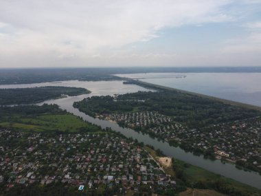 Yukarıdan suyla kaplı bir manzara. Kumlu sahil ve dalgalı okyanus manzarası. Fotoğraf yukarıdan bir dron tarafından çekildi. Doğa manzarası. Yeşil çimenli bir ormanın havadan görünüşü.