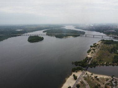 Yukarıdan suyla kaplı bir manzara. Kumlu sahil ve dalgalı okyanus manzarası. Fotoğraf yukarıdan bir dron tarafından çekildi. Doğa manzarası. Yeşil çimenli bir ormanın havadan görünüşü.