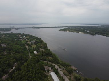 Yukarıdan suyla kaplı bir manzara. Kumlu sahil ve dalgalı okyanus manzarası. Fotoğraf yukarıdan bir dron tarafından çekildi. Doğa manzarası. Yeşil çimenli bir ormanın havadan görünüşü.
