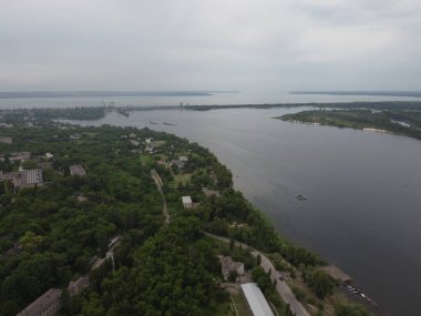 Yukarıdan suyla kaplı bir manzara. Kumlu sahil ve dalgalı okyanus manzarası. Fotoğraf yukarıdan bir dron tarafından çekildi. Doğa manzarası. Yeşil çimenli bir ormanın havadan görünüşü.
