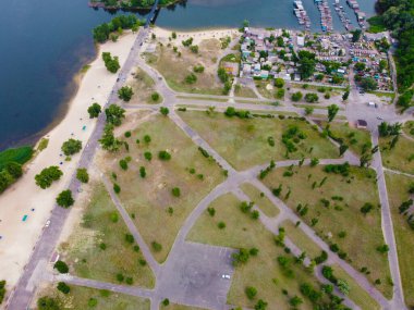Yukarıdan suyla kaplı bir manzara. Kumlu sahil ve dalgalı okyanus manzarası. Fotoğraf yukarıdan bir dron tarafından çekildi. Doğa manzarası. Yeşil çimenli bir ormanın havadan görünüşü.