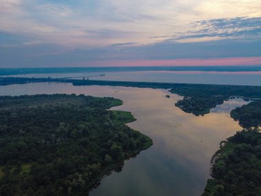 Yukarıdan suyla kaplı bir manzara. Kumlu sahil ve dalgalı okyanus manzarası. Fotoğraf yukarıdan bir dron tarafından çekildi. Doğa manzarası. Yeşil çimenli bir ormanın havadan görünüşü.