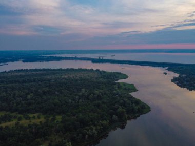 Yukarıdan suyla kaplı bir manzara. Kumlu sahil ve dalgalı okyanus manzarası. Fotoğraf yukarıdan bir dron tarafından çekildi. Doğa manzarası. Yeşil çimenli bir ormanın havadan görünüşü.