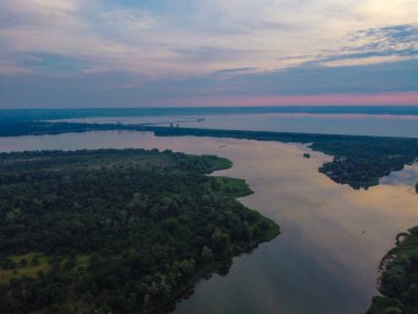 Yukarıdan suyla kaplı bir manzara. Kumlu sahil ve dalgalı okyanus manzarası. Fotoğraf yukarıdan bir dron tarafından çekildi. Doğa manzarası. Yeşil çimenli bir ormanın havadan görünüşü.