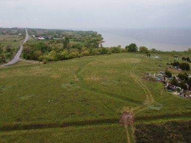 Yukarıdan suyla kaplı bir manzara. Kumlu sahil ve dalgalı okyanus manzarası. Fotoğraf yukarıdan bir dron tarafından çekildi. Doğa manzarası. Yeşil çimenli bir ormanın havadan görünüşü.