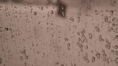 Kar camda erir. Bir arabanın camında kar taneleri. Camın arkasındaki yağmur damlaları. Islak karda pencere. Kötü hava. Kar yağışı. Soyut arkaplan. Kar ve yağmur.