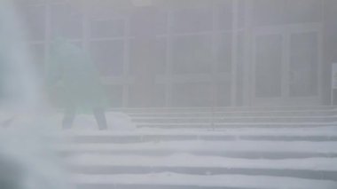 Kar temizleme. İnsanlar kar kürür. Merdivenlerde kar var. Kürekli bir adam ve kadın. Kar fırtınası. Kötü hava. Soyutlama. Bulanık arkaplan.