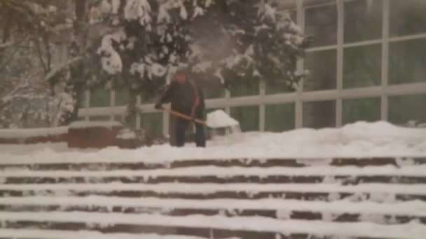 雪の除去 人々は雪をシャベル 雪が積もってる シャベルを持った男と女 ブリザード 悪天候だ 抽象化です 背景がぼやけて — ストック動画