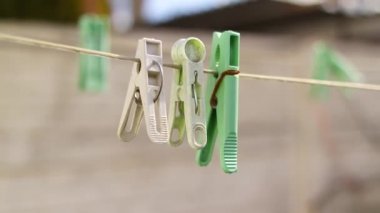 İpteki eski kazıklar. Keten bir ipe bağlanmış eski bir mandal. Evde çalış, çamaşır yıka, çarşaf kurula. Eski Kirli Mavi ve Pembe elbise askısı. Arka planda izole edilmiş bir halat.