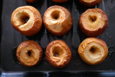 Fırında elma. Ballı elma. Beyaz arka planda tatlı bir tabakta cevizle doldurulmuş fırında elma. Elma ballı ve tarçınlı.