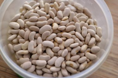 Beyaz fasulye. Bir avuç beyaz fasulye. Beyaz fasulye taneleri görünür detaylarla