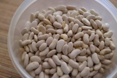 Beyaz fasulye. Bir avuç beyaz fasulye. Beyaz fasulye taneleri görünür detaylarla