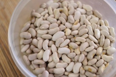 Beyaz fasulye. Bir avuç beyaz fasulye. Beyaz fasulye taneleri görünür detaylarla