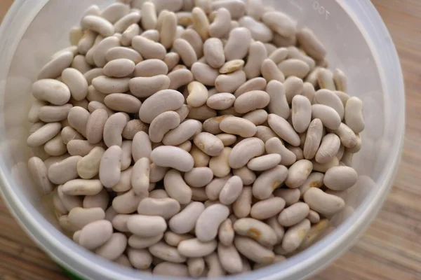 Beyaz fasulye. Bir avuç beyaz fasulye. Beyaz fasulye taneleri görünür detaylarla