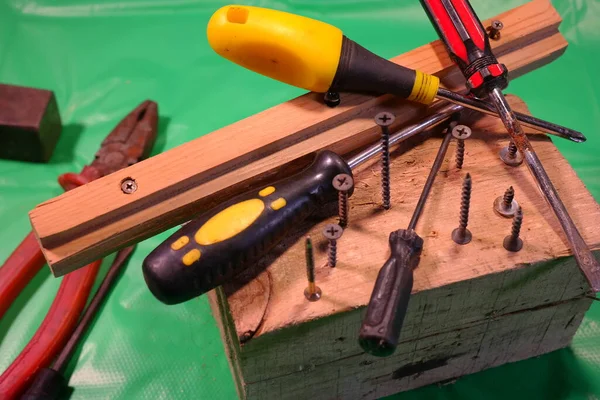 用螺丝刀拧 螺丝刀和螺丝 在车间工作 螺丝刀螺钉在金属板螺栓 螺钉和螺母 在木工车间用木料工作 — 图库照片